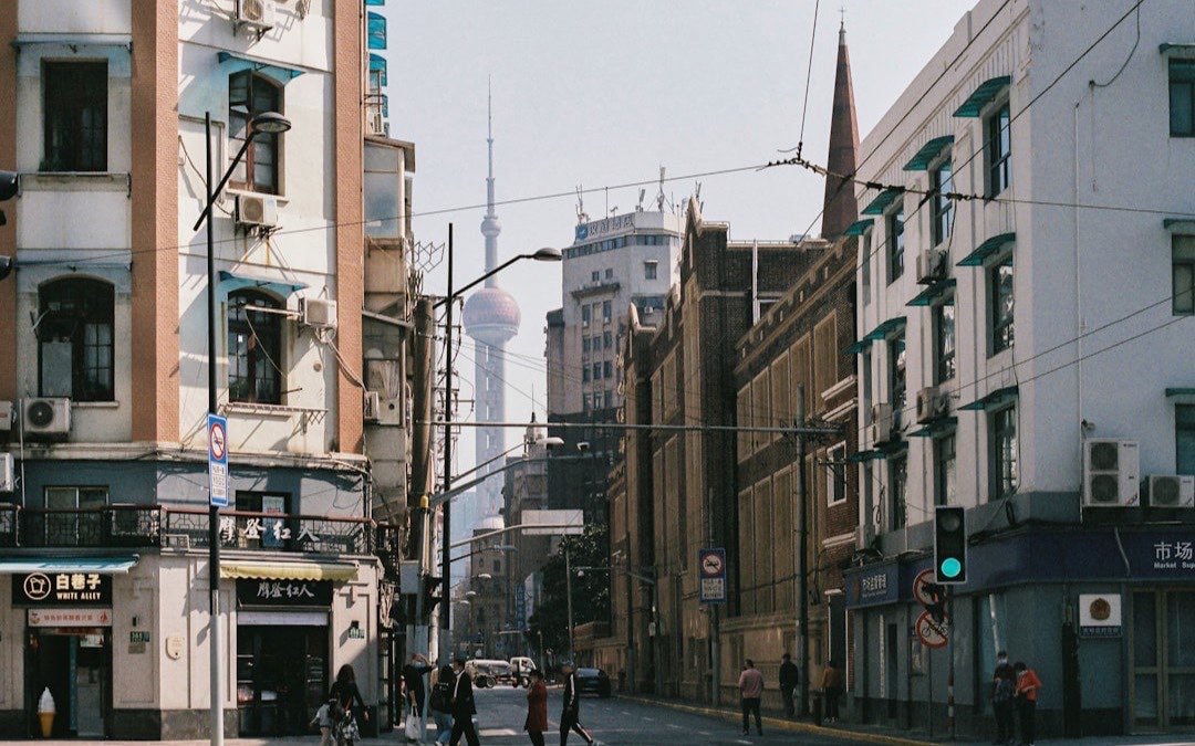Pedestrians walking past street-level shops and cafes in Shanghai