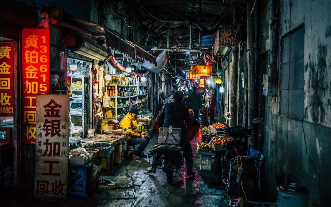 Customers paying by QR code in a small Shanghai store at night, where Alipay and WeChat Pay mobile payments are the norm