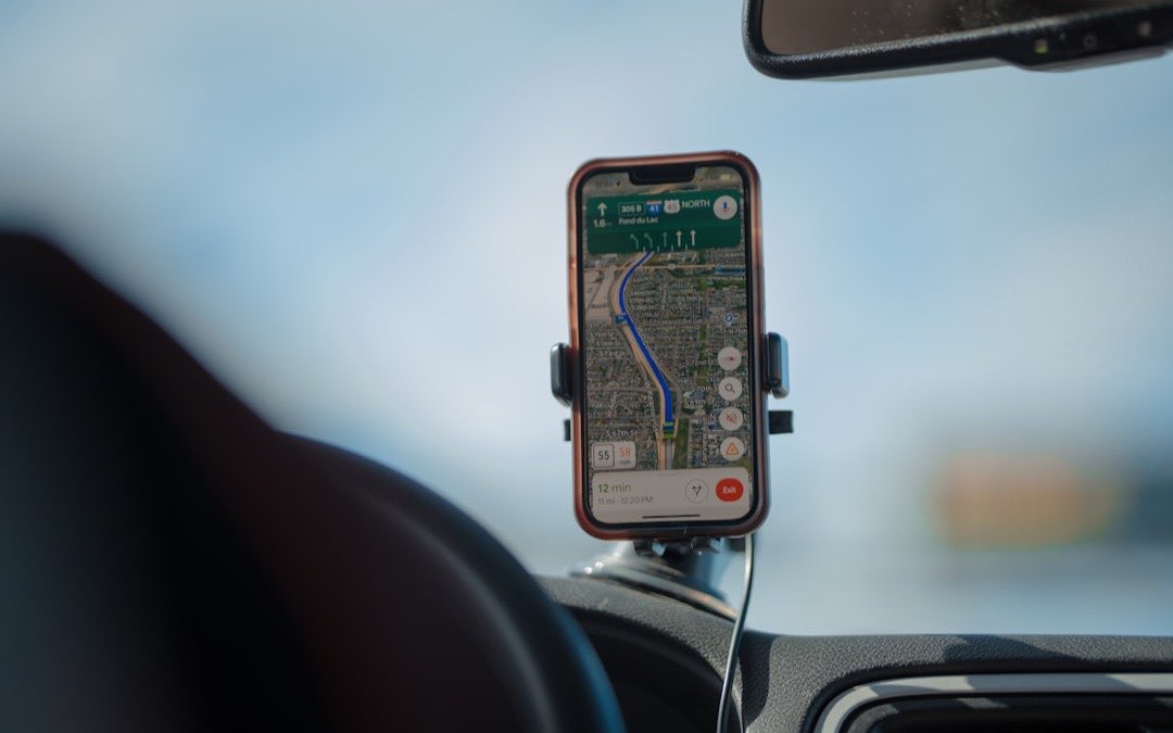 Hand holding a smartphone using mobile data to run a navigation app